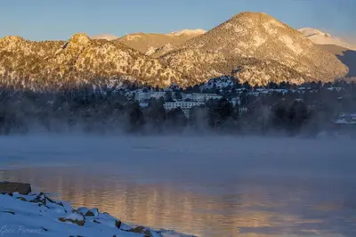 a view of a lake with mountains in the background at Tranquility On The River Four -- EV #6041 townhouse in Estes Park