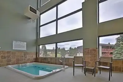 a hot tub in a room with windows at Hi Country Haus Getaway in Winter Park