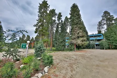 a building in the middle of a forest of trees at Hi Country Haus Getaway in Winter Park