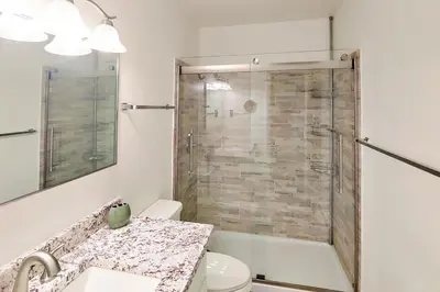 a bathroom with a shower and a toilet and a sink at Hi Country Haus Getaway in Winter Park