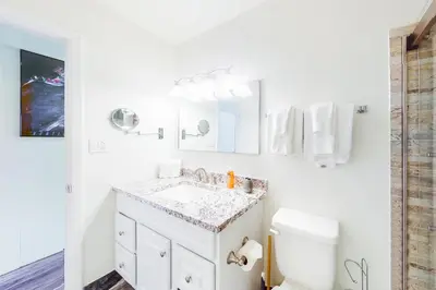 a white bathroom with a sink and a toilet at Hi Country Haus Getaway in Winter Park