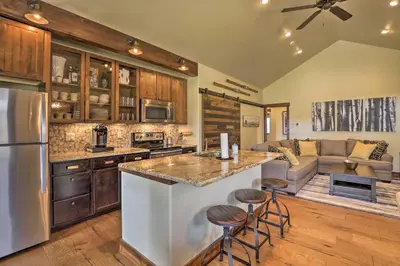 a kitchen with a counter and a living room at Walk to Main St and Marina Grand Lake Cabin! in Grand Lake