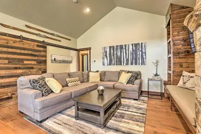 a living room with a couch and a table at Walk to Main St and Marina Grand Lake Cabin! in Grand Lake