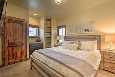 a bedroom with a large bed and a wooden door at Walk to Main St and Marina Grand Lake Cabin! in Grand Lake