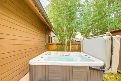 a jacuzzi tub in the backyard of a house at Walk to Main St and Marina Grand Lake Cabin! in Grand Lake