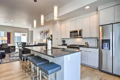 a kitchen with a large island with bar stools at Trendy Denver Townhome - Walk to Mile High Stadium in Denver