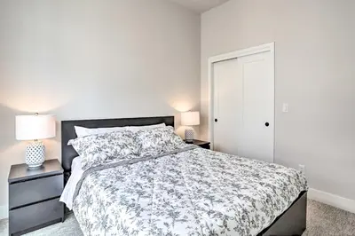 a bedroom with a bed and two lamps and a door at Trendy Denver Townhome - Walk to Mile High Stadium in Denver