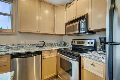 a kitchen with wooden cabinets and stainless steel appliances at River Run Village by Vail Resorts in Keystone