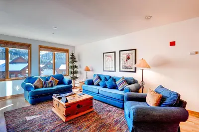 a living room with blue couches and a table at Gateway Mountain Lodge, A Vail Resorts Property in Keystone