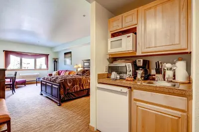 a kitchen and a bedroom with a bed in a room at Gateway Mountain Lodge, A Vail Resorts Property in Keystone