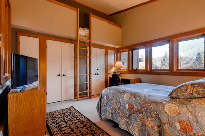 a bedroom with a bed and a flat screen tv at Aspen Ridge Condominiums by Vail Resorts in Keystone