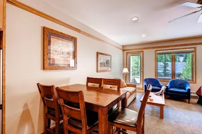 a living room with a wooden table and chairs at Mountain House, A Vail Resorts Property in Keystone