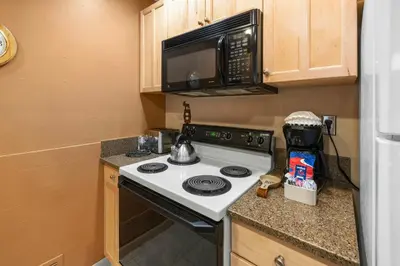 a small kitchen with a stove and a microwave at Mountain House, A Vail Resorts Property in Keystone
