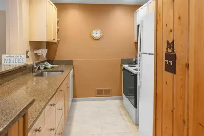 a kitchen with a white refrigerator and a sink at Mountain House, A Vail Resorts Property in Keystone