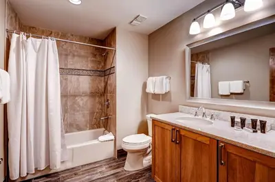 a bathroom with a sink and a toilet and a mirror at Mountain House, A Vail Resorts Property in Keystone