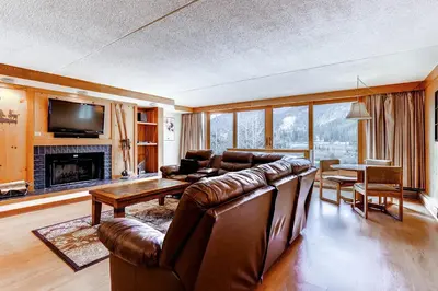a living room with a leather couch and a table at Lakeside Village by Vail Resorts in Keystone