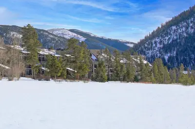 a large snow covered field in front of a building at Evergreen Condominiums by Vail Resorts in Keystone