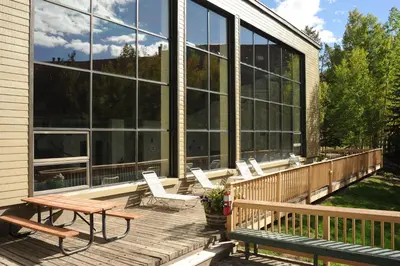 a deck with chairs and a picnic table on a house at Evergreen Condominiums by Vail Resorts in Keystone