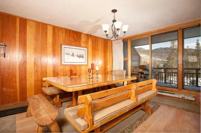 a dining room with a table and benches and a window at Evergreen Condominiums by Vail Resorts in Keystone