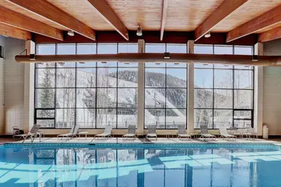 a large swimming pool with chairs and a large window at Evergreen Condominiums by Vail Resorts in Keystone
