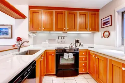 a kitchen with wooden cabinets and a black oven at Forest Condominiums by Vail Resorts in Keystone