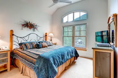 a bedroom with a bed and a flat screen tv at Forest Condominiums by Vail Resorts in Keystone