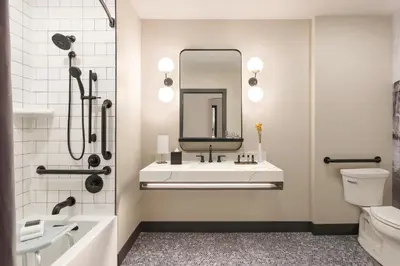 a bathroom with a sink and a toilet and a mirror at The Eddy Taproom & Hotel in Golden
