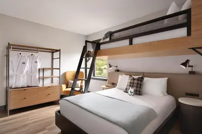 a bedroom with a bunk bed and a chair at The Eddy Taproom & Hotel in Golden