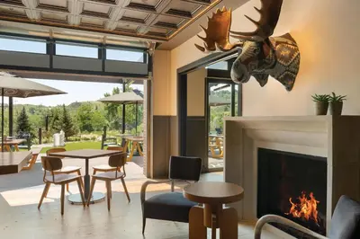 a living room with a fireplace and a table and chairs at The Eddy Taproom & Hotel in Golden