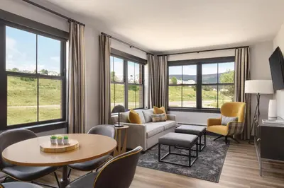 a living room with a table and chairs and windows at The Eddy Taproom & Hotel in Golden
