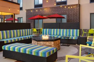 a patio with couches and a table and chairs at Home2 Suites by Hilton Denver West / Federal Center in Lakewood