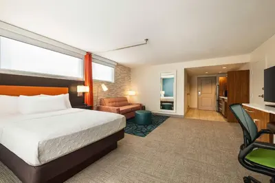 a hotel room with a bed and a living room at Home2 Suites by Hilton Denver West / Federal Center in Lakewood