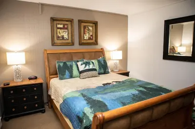 a bedroom with a bed and two lamps and a mirror at 1168 Flying Dutchman condo in Keystone
