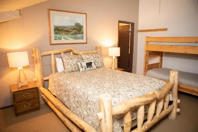 a bedroom with a wooden bed and two bunk beds at 1168 Flying Dutchman condo in Keystone