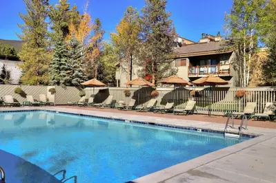 a swimming pool with chairs and umbrellas at 1168 Flying Dutchman condo in Keystone