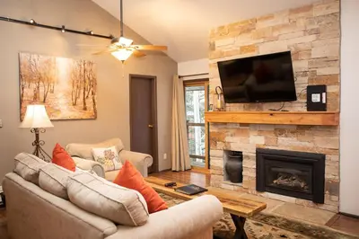 a living room with a fireplace and a flat screen tv at 1168 Flying Dutchman condo in Keystone