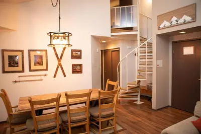 a dining room with a table and chairs and a staircase at 1168 Flying Dutchman condo in Keystone