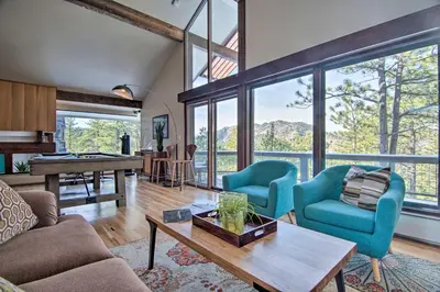 a living room with two blue chairs and a table at Chic Boulder Mountain Home with Hot Tub and Views in Boulder