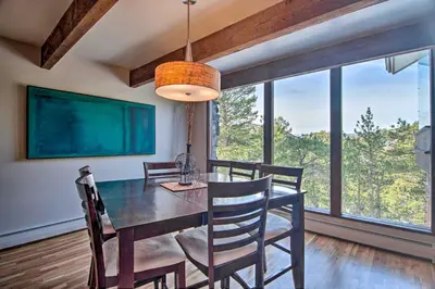 a dining room with a table and chairs and a large window at Chic Boulder Mountain Home with Hot Tub and Views in Boulder