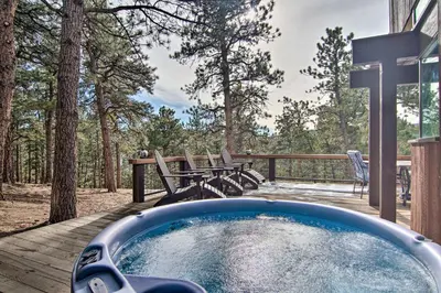 a hot tub on a deck with a table and chairs at Chic Boulder Mountain Home with Hot Tub and Views in Boulder