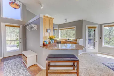 a kitchen with a counter and some windows at Mountain Views and Hot Tub Airy Forest Escape! in Black Hawk