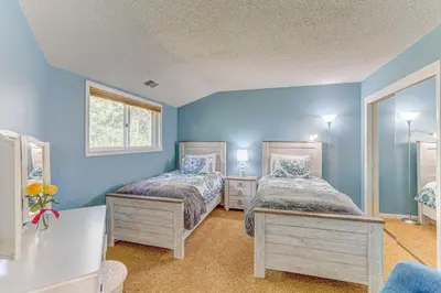 two beds in a room with blue walls at Mountain Views and Hot Tub Airy Forest Escape! in Black Hawk