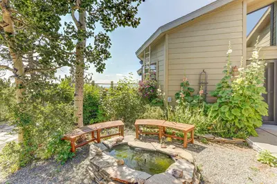 a backyard with two benches and a pond at Mountain Views and Hot Tub Airy Forest Escape! in Black Hawk