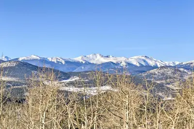 a snowy mountain range with trees and snow covered mountains at Mountain Views and Hot Tub Airy Forest Escape! in Black Hawk