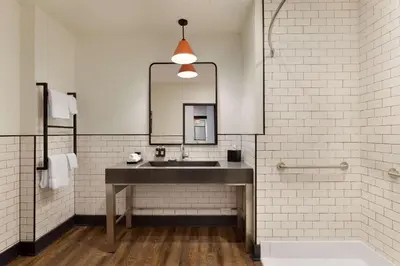 a bathroom with a sink and a mirror and a tub at Origin Westminster a Wyndham Hotel in Westminster
