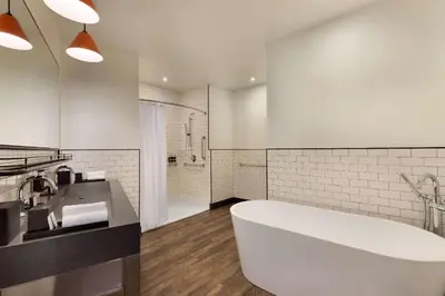 a white bathroom with a tub and a sink at Origin Westminster a Wyndham Hotel in Westminster