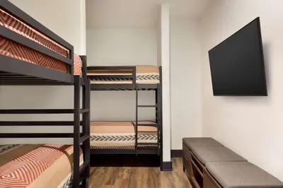 a room with two bunk beds and a flat screen tv at Origin Westminster a Wyndham Hotel in Westminster