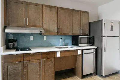 a kitchen with wooden cabinets and a white refrigerator at Homewood Suites By Hilton Dillon in Dillon