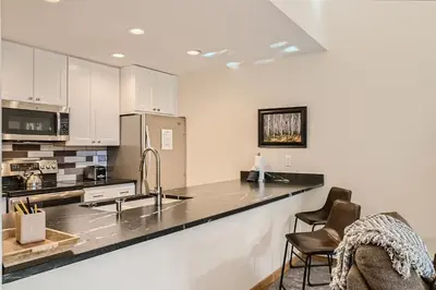 a kitchen with white cabinets and a black counter top at 2084 The Pines condo in Keystone
