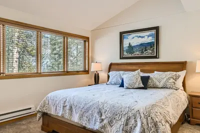 a bedroom with a bed and two windows at 2084 The Pines condo in Keystone